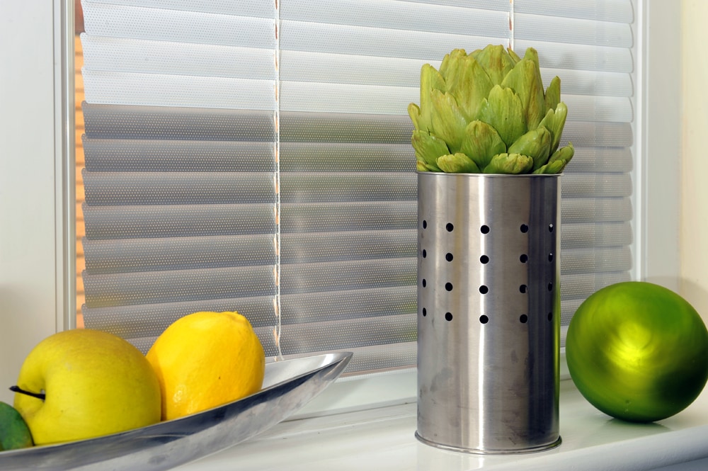 Silver grey kitchen venetian blinds with lemons and limes on window ledge. - Blinds Norfolk - Norwich Sunblinds