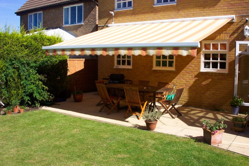 Bright stripy awnings providing shade for the garden terrace - Awnings Norfolk - Norwich Sunblinds