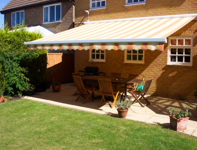 Bright stripy awnings providing shade for the garden terrace - Awnings Norfolk - Norwich Sunblinds