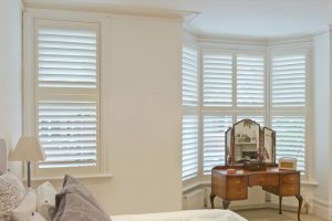 White shutters in a bedroom bay window - Shutters Norfolk - Norwich Sunblinds