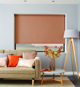 Copper coloured roller blind behind sofa in living room - Blinds Norfolk - Norwich Sunblinds