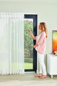 Lady opening Allusion blinds using wand - Blinds Norfolk - Norwich Sunblinds